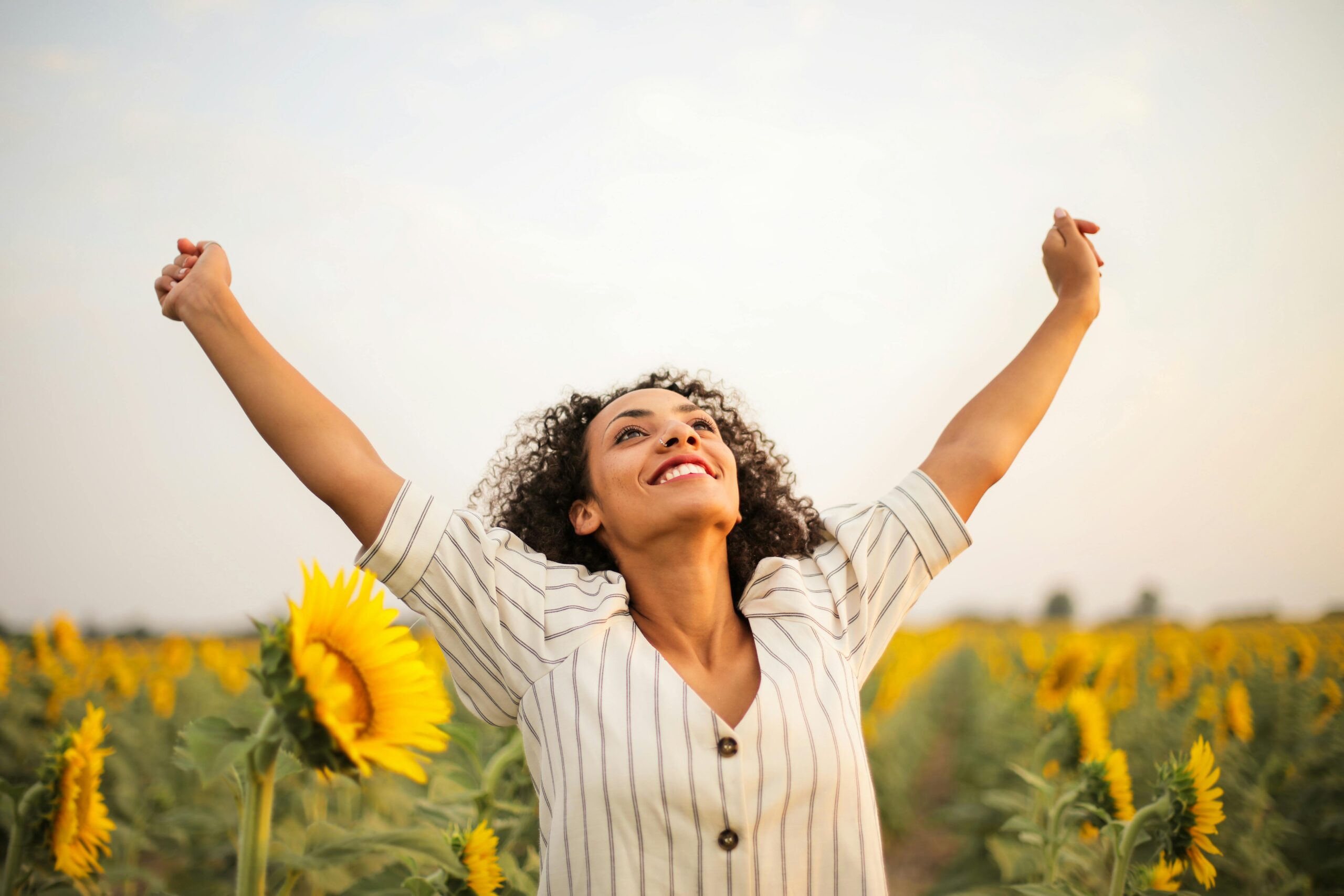 Your first appointment - young person is happy in a field of sunflowers as she is on her journey to finding her sweet spot with food